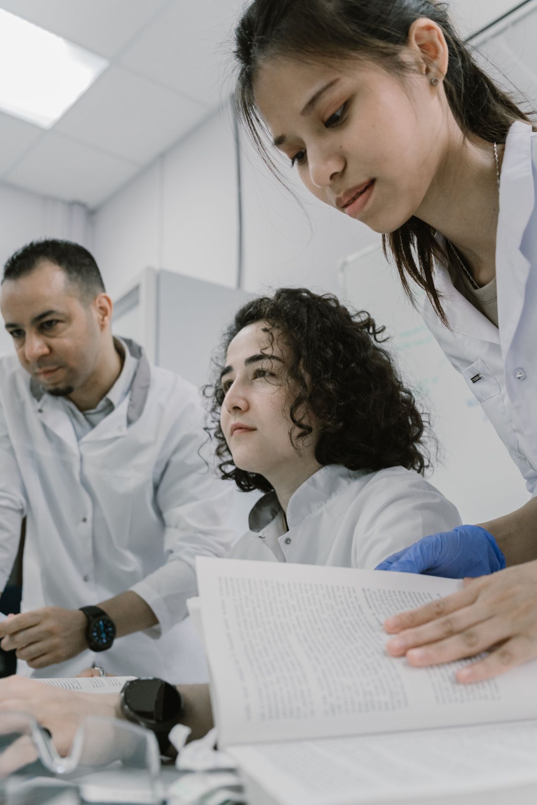 Diverse team of lab professionals reviewing study materials together